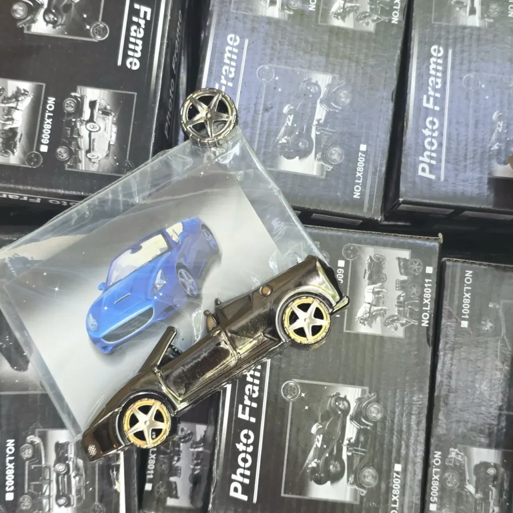 Marco de fotos de coche convertible metálico con ruedas doradas sobre cajas de marcos de fotos de coches. by Remates Narvaja