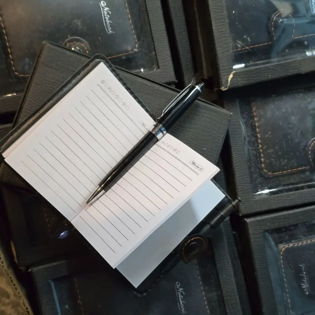 Bolígrafo negro sobre libreta de notas abierta con páginas rayadas. by Remates Narvaja