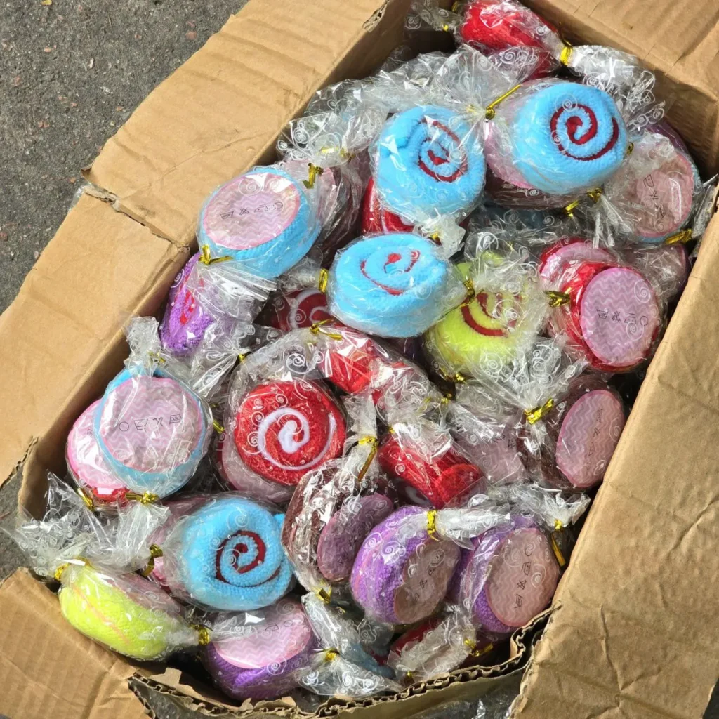 Caja de toallas pequeñas de colores envueltas individualmente, algunas con forma de caramelo o piruleta." by Remates Narvaja