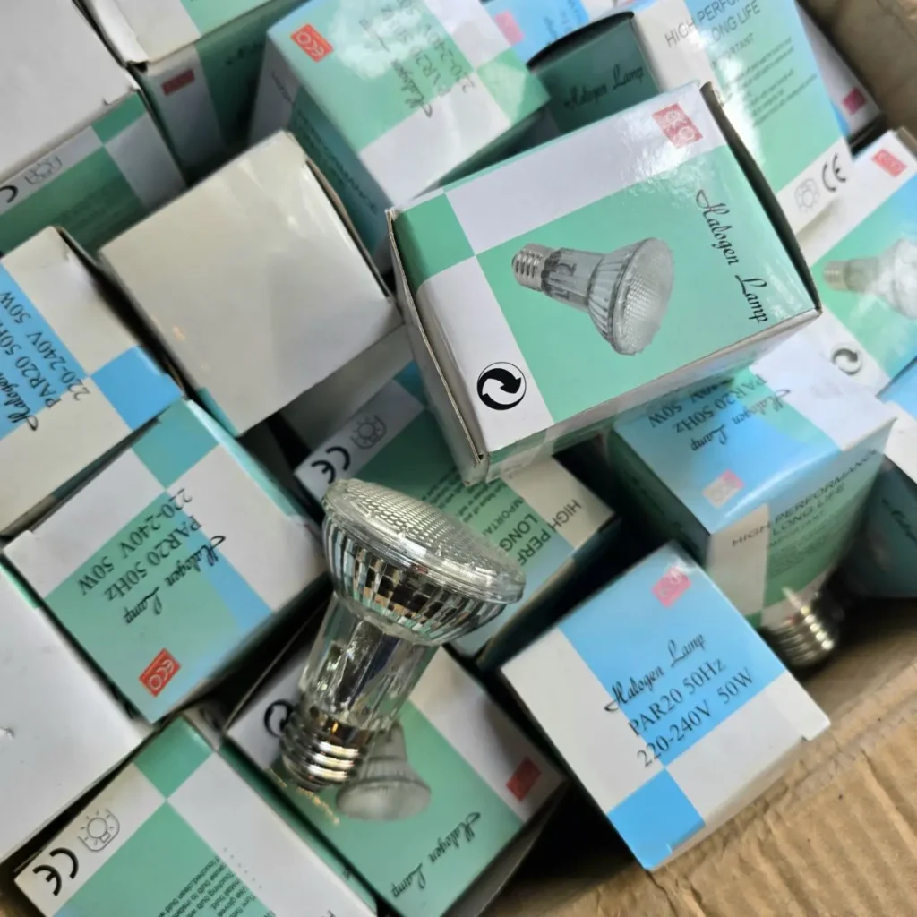 Cajas de bombillas halógenas PAR20 de 50W apiladas, con una bombilla suelta visible. by Remates Narvaja