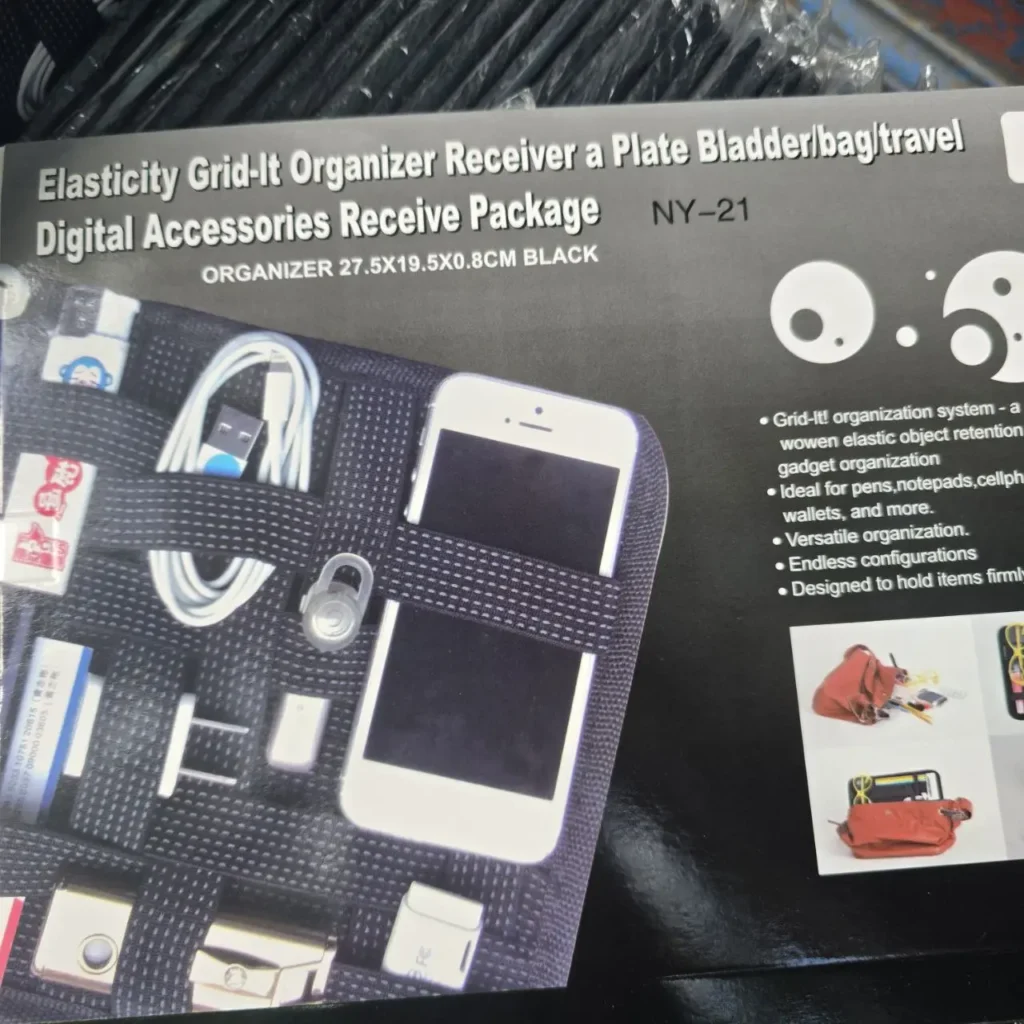 Organizador Grid-It negro para accesorios digitales y electrónicos de viaje, mostrando teléfonos y cables. by Remates Narvaja