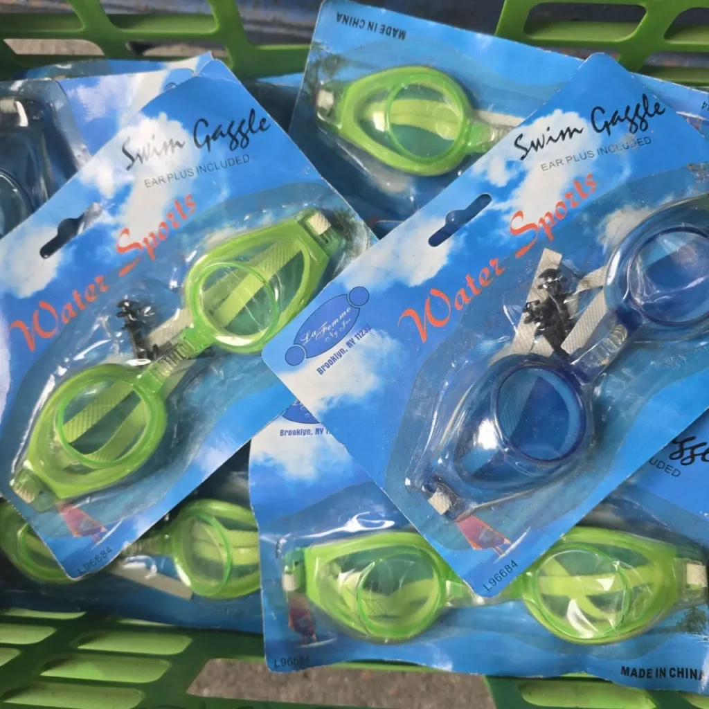 Gafas de natación "Swim Gaggle" verdes y azules en sus empaques, con la etiqueta "Water Sports" y "Ear by Remates Narvaja