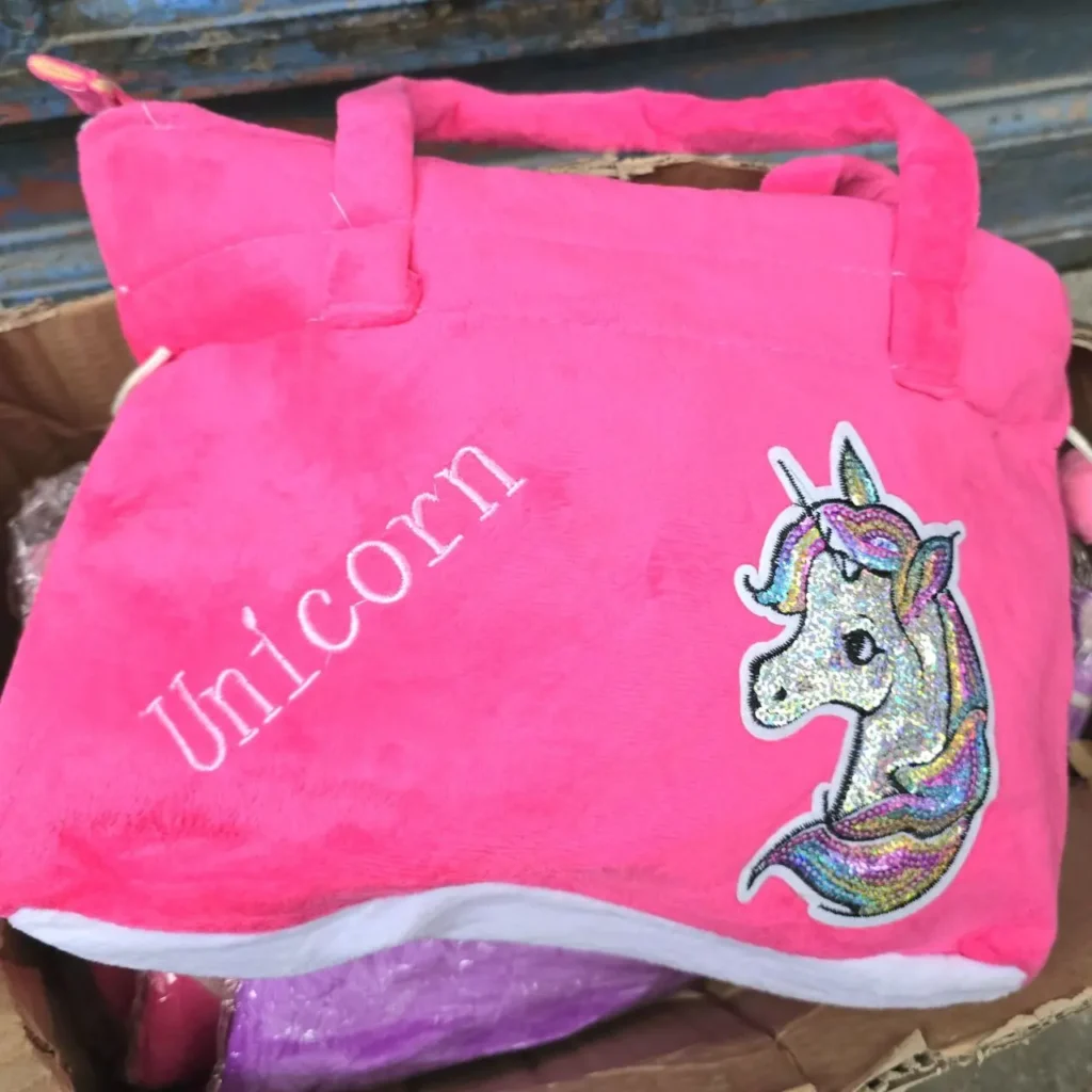 Bolso de felpa rosa brillante con texto "Unicorn" y parche de cabeza de unicornio con purpurina. by Remates Narvaja