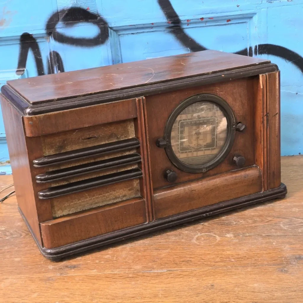 Radio vintage de madera oscura con dial circular y rejilla de altavoz. by Remates Narvaja