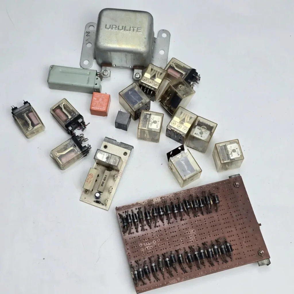 Colección de componentes electrónicos vintage: relés, placas de circuito impreso y una carcasa metálica. by Remates Narvaja