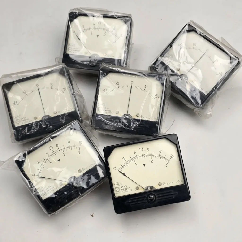 Seis microamperímetros analógicos, la mayoría en su embalaje de plástico. Presentan marcos negros y esferas blancas con escalas y by Remates Narvaja