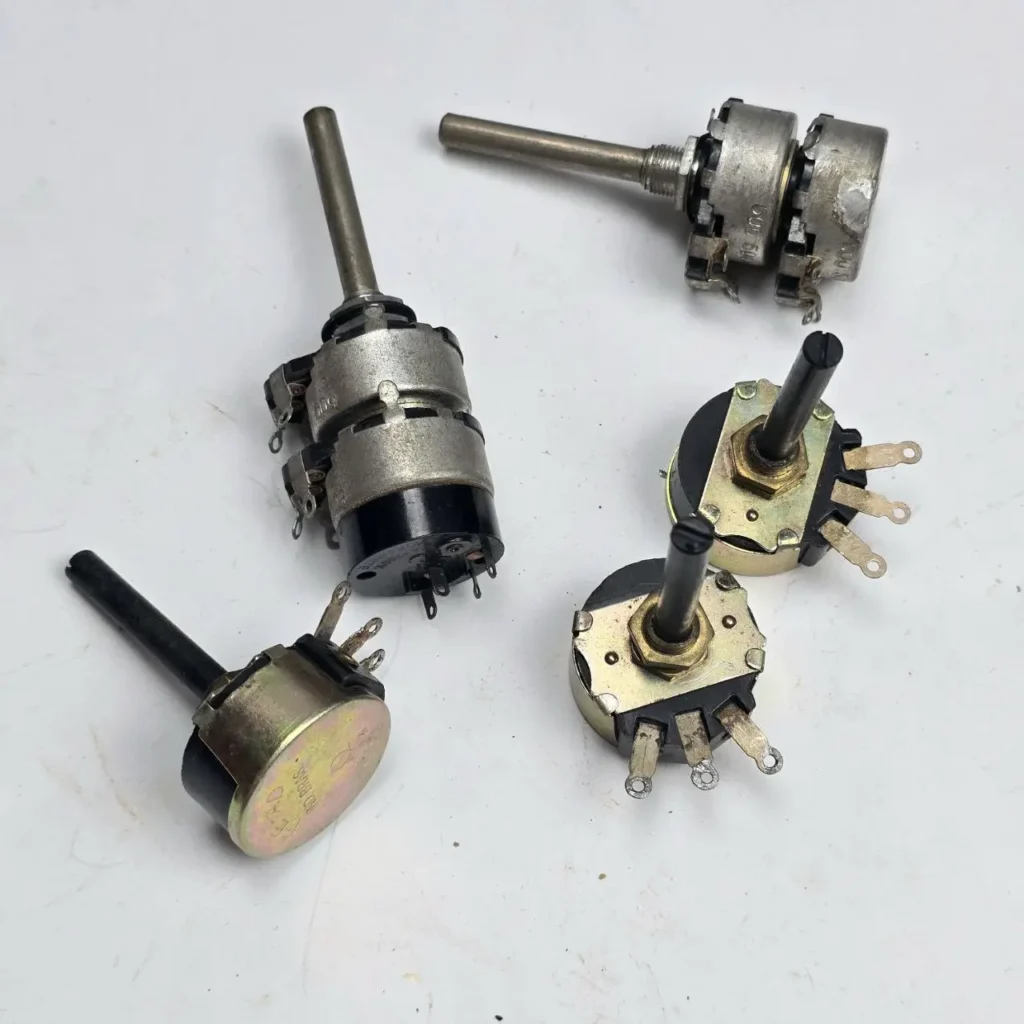 Varias unidades de potenciómetros electrónicos, incluyendo modelos de una, dos y tres secciones (gang), con ejes y terminales, sobre un by Remates Narvaja