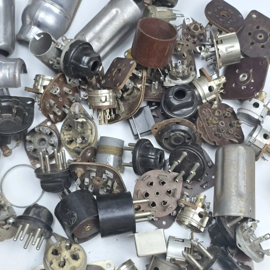 Pila de componentes electrónicos vintage, incluyendo zócalos de tubos de vacío y conectores. by Remates Narvaja