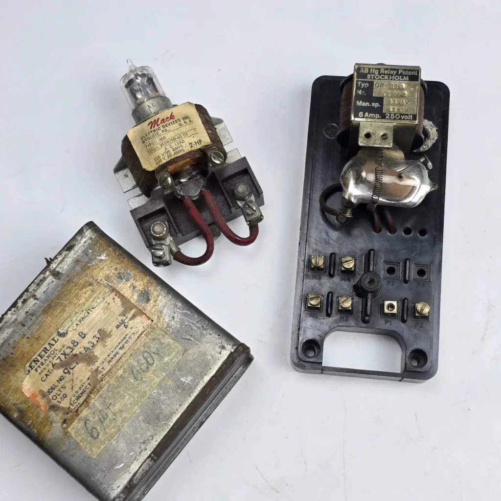 Componentes eléctricos vintage: un relé Mack Electric Devices, un relé de mercurio AB Hg de Estocolmo y un capacitor General Electric Pyran by Remates Narvaja