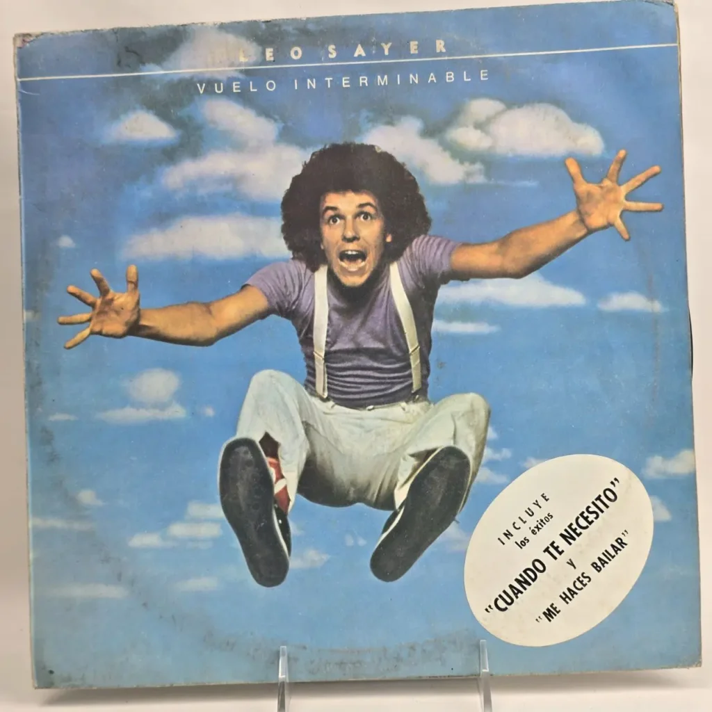 Portada del álbum "Vuelo Interminable" de Leo Sayer, con el artista saltando en el cielo azul y nubes, y by Remates Narvaja