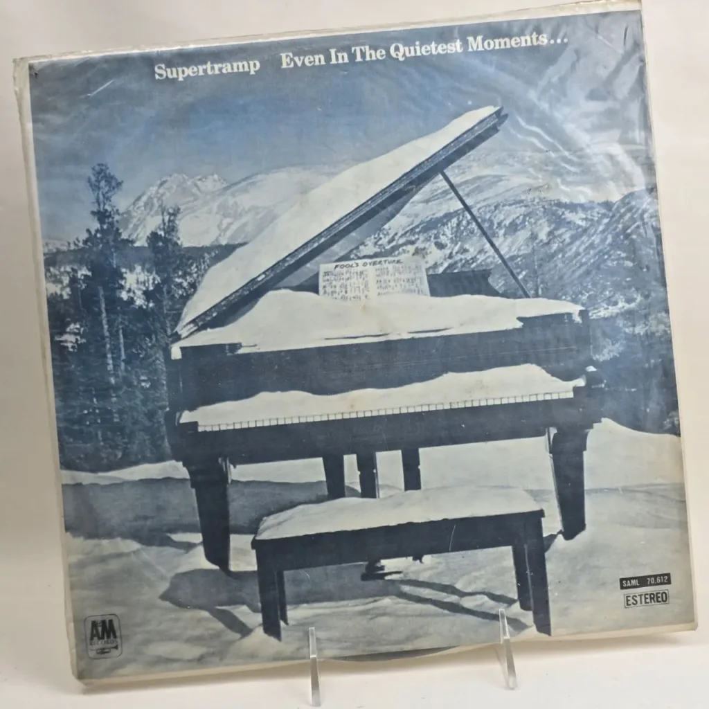 Portada del álbum Supertramp Even In The Quietest Moments, con un piano de cola cubierto de nieve en un paisaje montañoso invernal. by Remates Narvaja