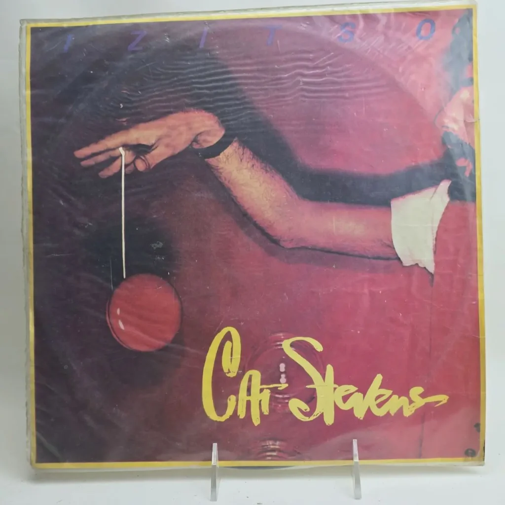 Portada del álbum de vinilo Cat Stevens IZITSO con una mano sosteniendo un yo-yo rojo. by Remates Narvaja