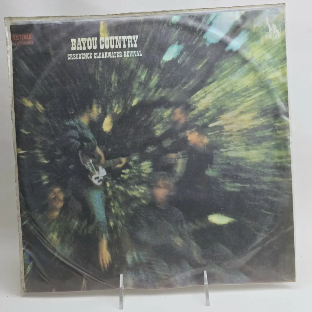Álbum de vinilo Bayou Country de Creedence Clearwater Revival, con la portada original de la banda en un entorno boscoso oscuro. by Remates Narvaja