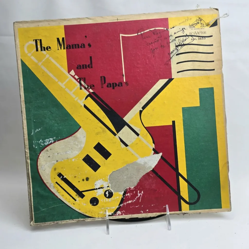 Cubierta de álbum vintage de The Mamas and The Papas con diseño de trombón amarillo estilizado sobre bloques rojos, amarillos y verdes, autograf by Remates Narvaja