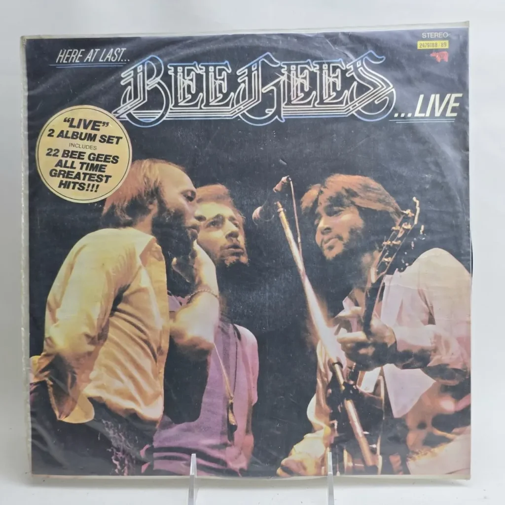 Portada del álbum de vinilo Bee Gees Here At Last... Live, set de 2 discos con sus mayores éxitos, mostrando a la banda tocando en by Remates Narvaja