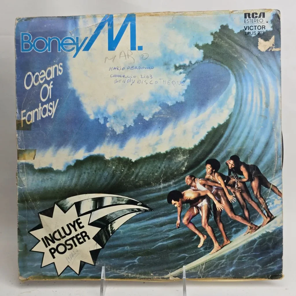 Portada de álbum vintage Boney M. Oceans Of Fantasy con la banda surfeando una gran ola. Incluye póster. by Remates Narvaja