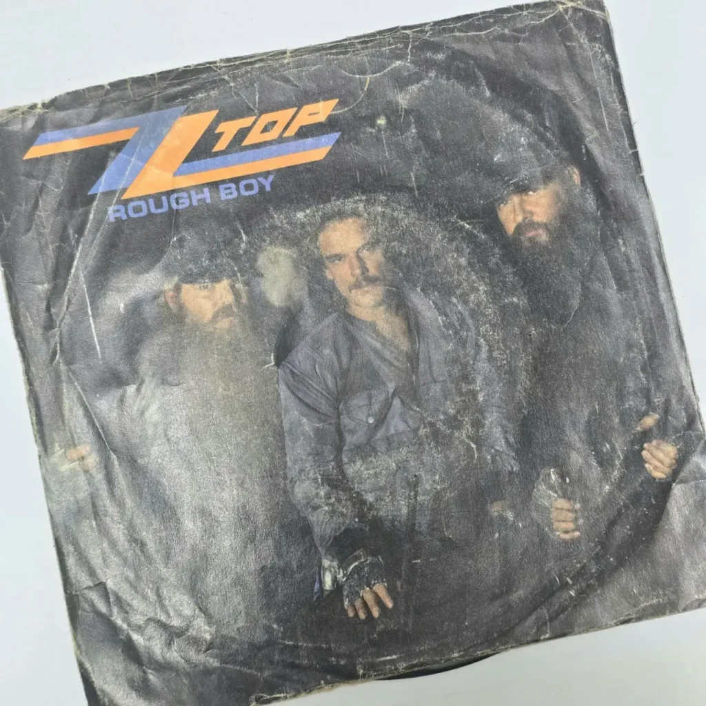 Cubierta de single de ZZ Top "Rough Boy" desgastada con los miembros de la banda. by Remates Narvaja