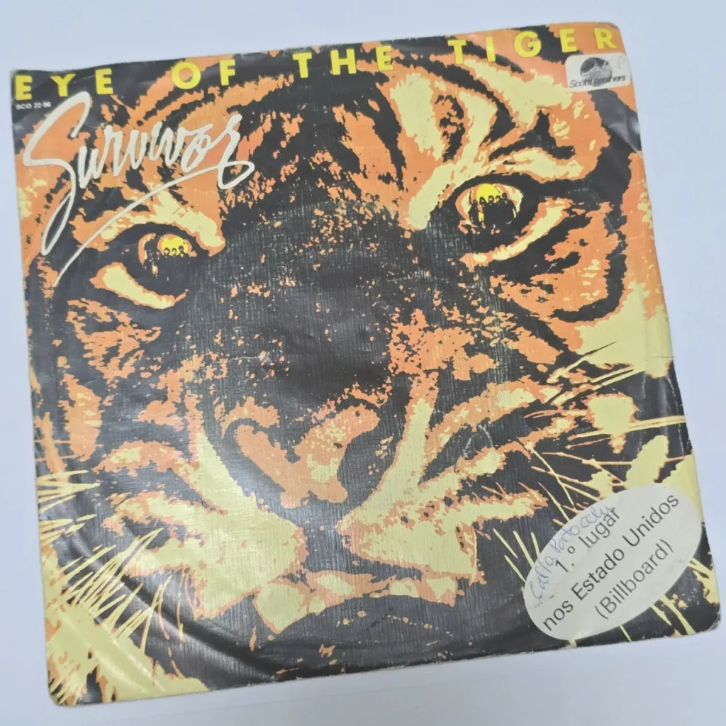 Portada de vinilo del single 'Eye of the Tiger' de Survivor, con ilustración de cara de tigre naranja y negro, destacando su puesto número by Remates Narvaja