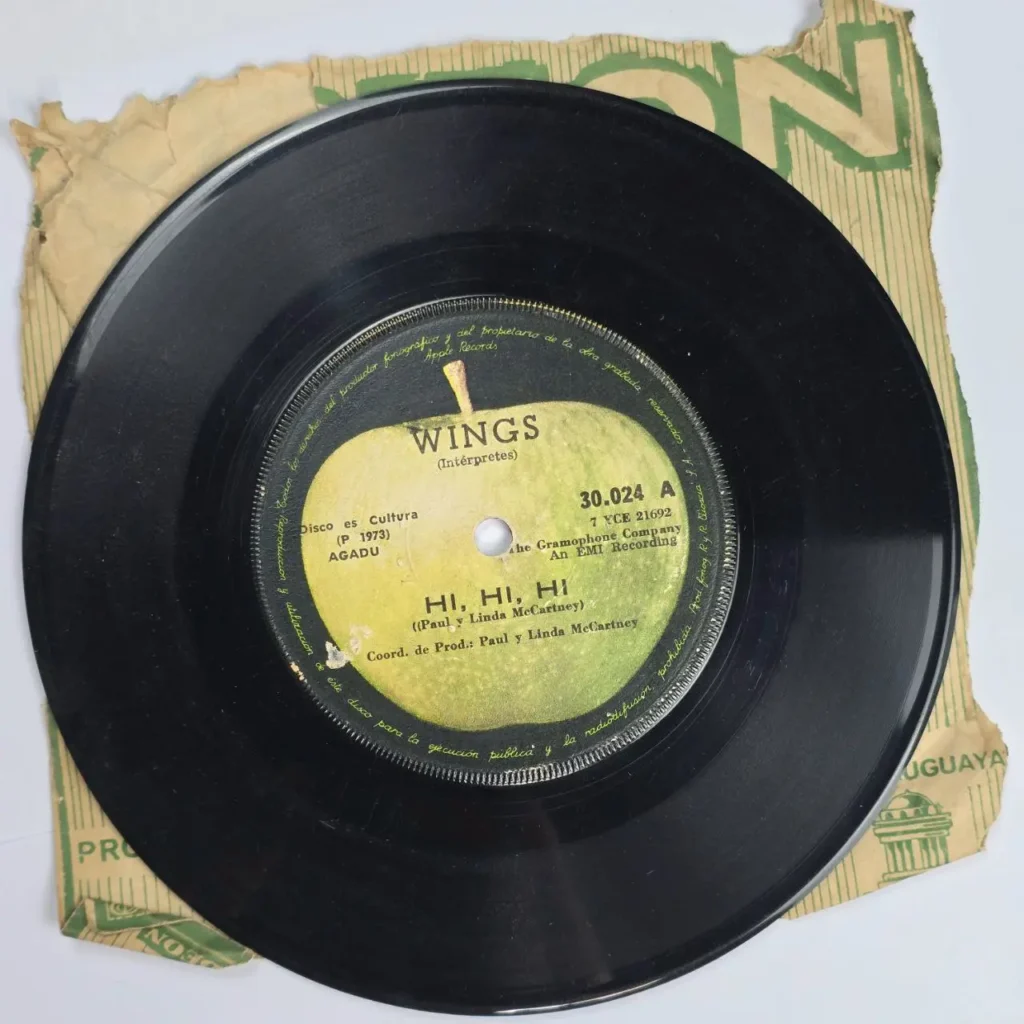 Disco de vinilo negro de Wings "Hi, Hi, Hi" (1973) con sello Apple Records, sobre funda de papel marrón by Remates Narvaja