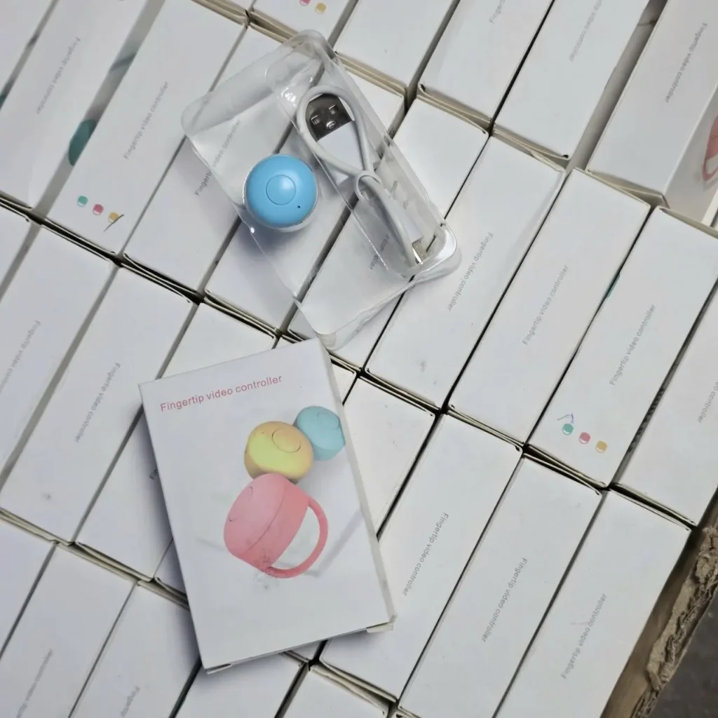 Cajas de controladores de video de dedo, con un dispositivo azul abierto y cable USB, y un empaque mostrando controladores de colores. by Remates Narvaja