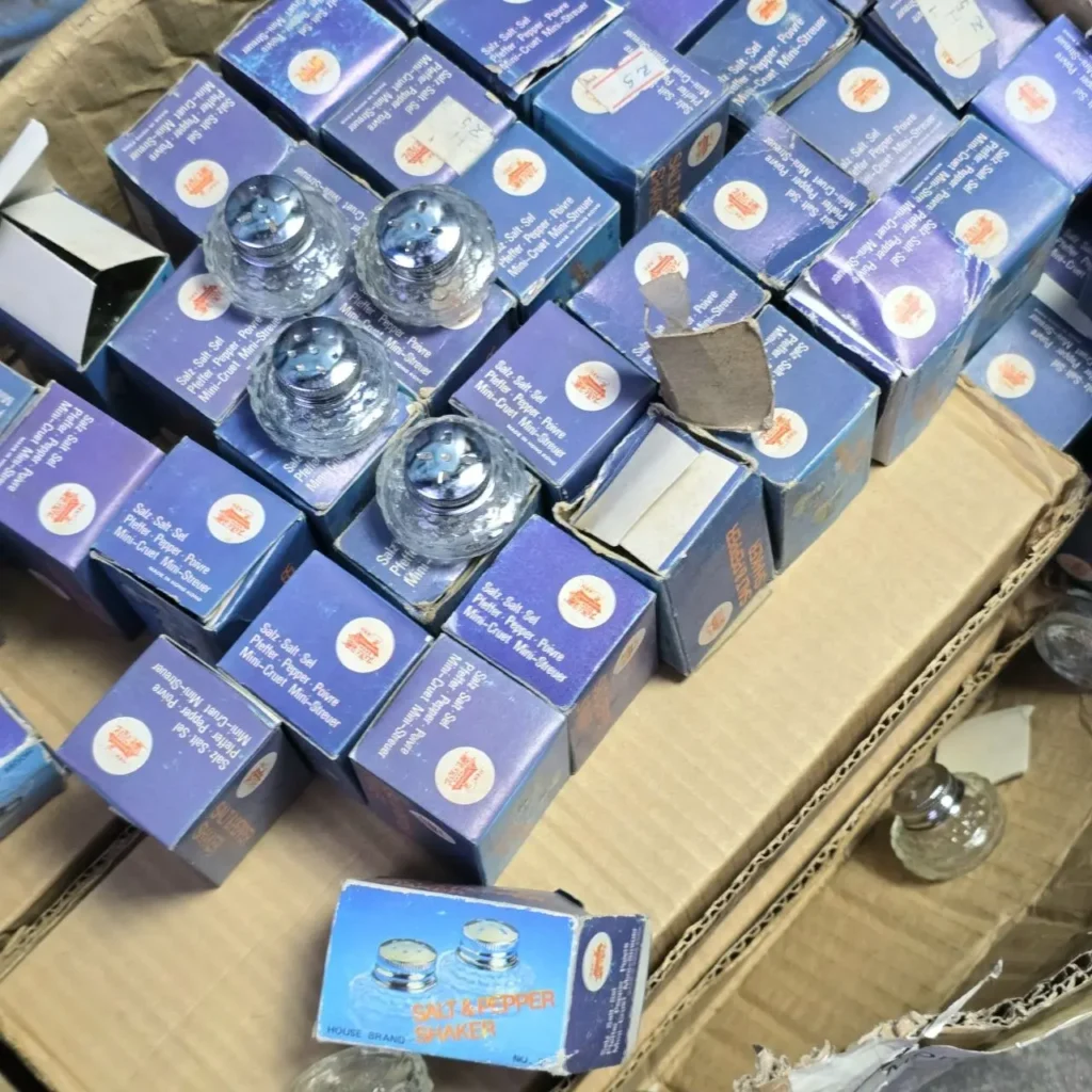 Cajas azules con mini saleros y pimenteros de vidrio apilados. by Remates Narvaja