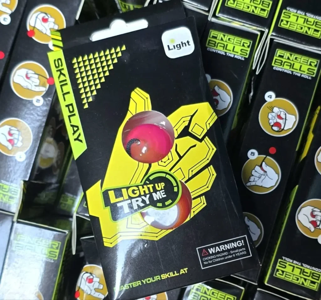 Pilas de paquetes de Finger Balls Light Up, juguetes de habilidad en empaque negro y amarillo. by Remates Narvaja