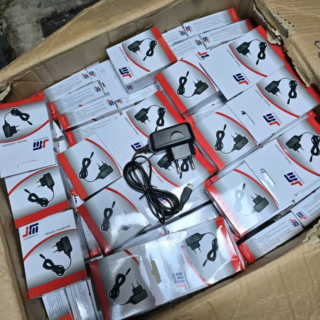 Caja llena de cargadores de viaje USB negros empaquetados. by Remates Narvaja