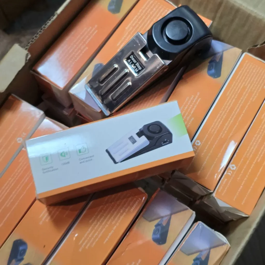 Varias alarmas de tope de puerta en cajas naranjas. by Remates Narvaja