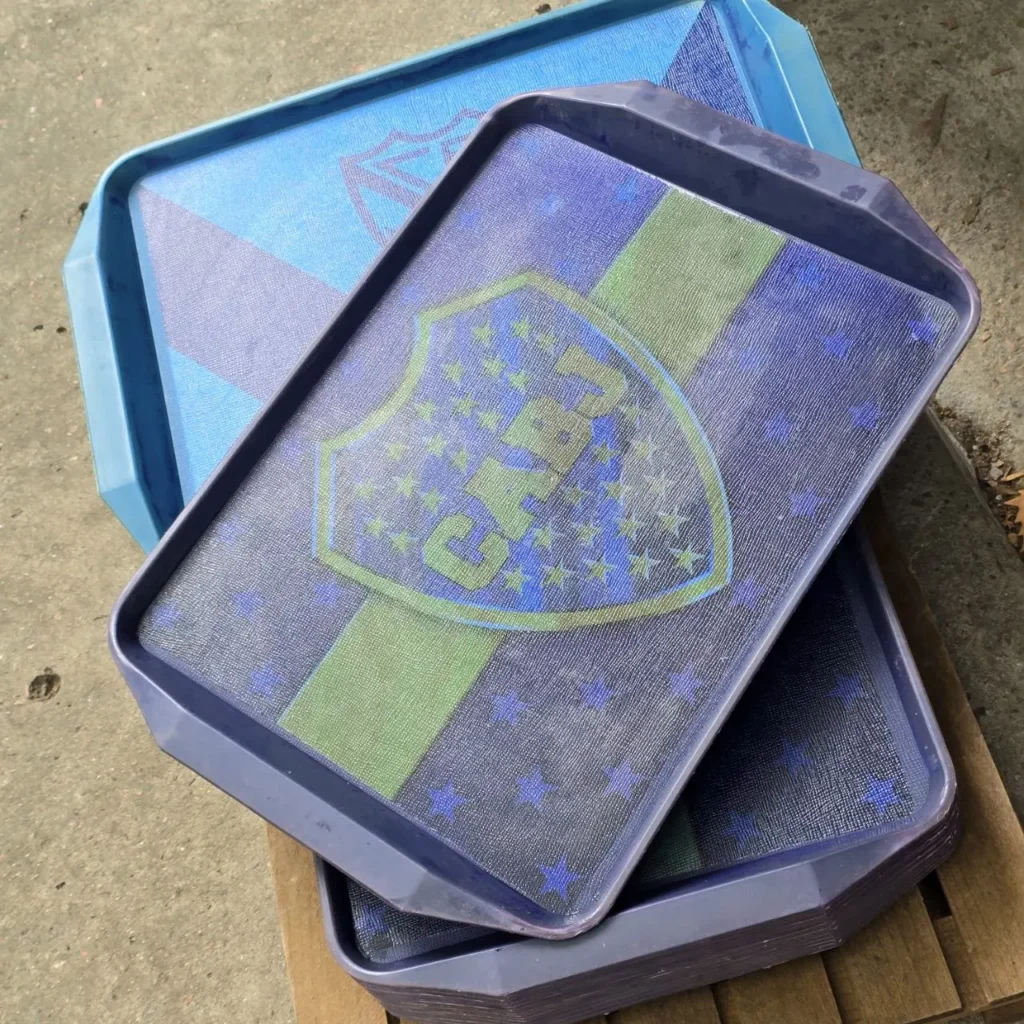 Bandejas apiladas de plástico azul oscuro con el escudo de Boca Juniors, estrellas y franja verde. by Remates Narvaja