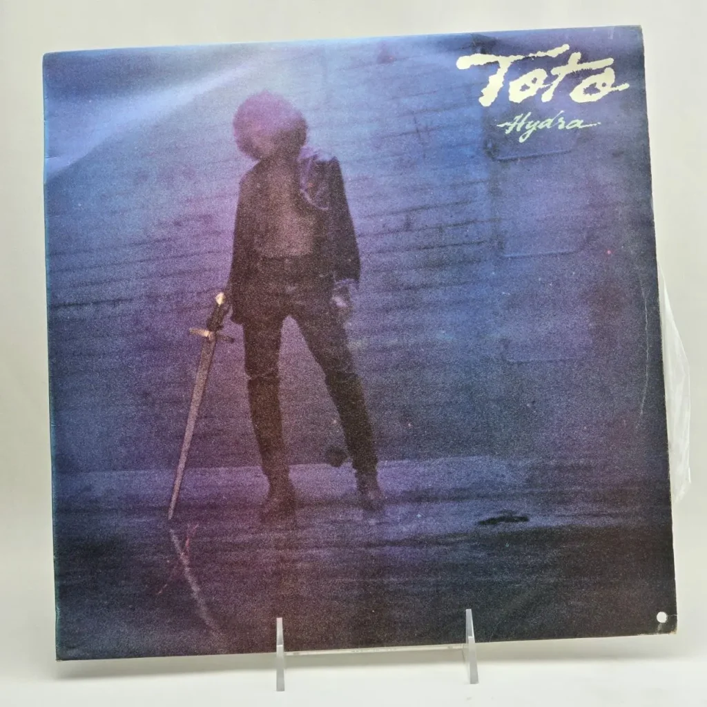 Portada del álbum de vinilo Toto Hydra con figura de hombre y espada." by Remates Narvaja