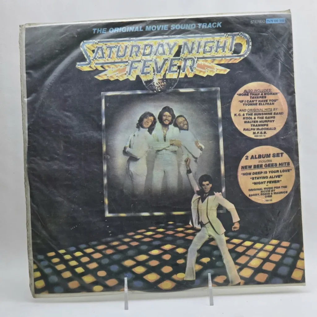 Portada del álbum de vinilo Saturday Night Fever, con John Travolta en pose disco y los Bee Gees. by Remates Narvaja
