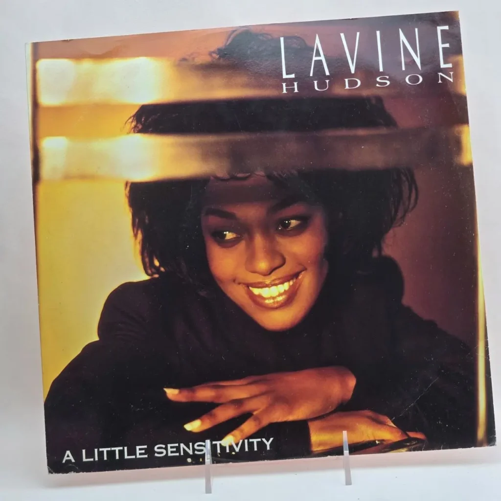 Portada del single "A Little Sensitivity" de Lavine Hudson, con la artista sonriendo. by Remates Narvaja