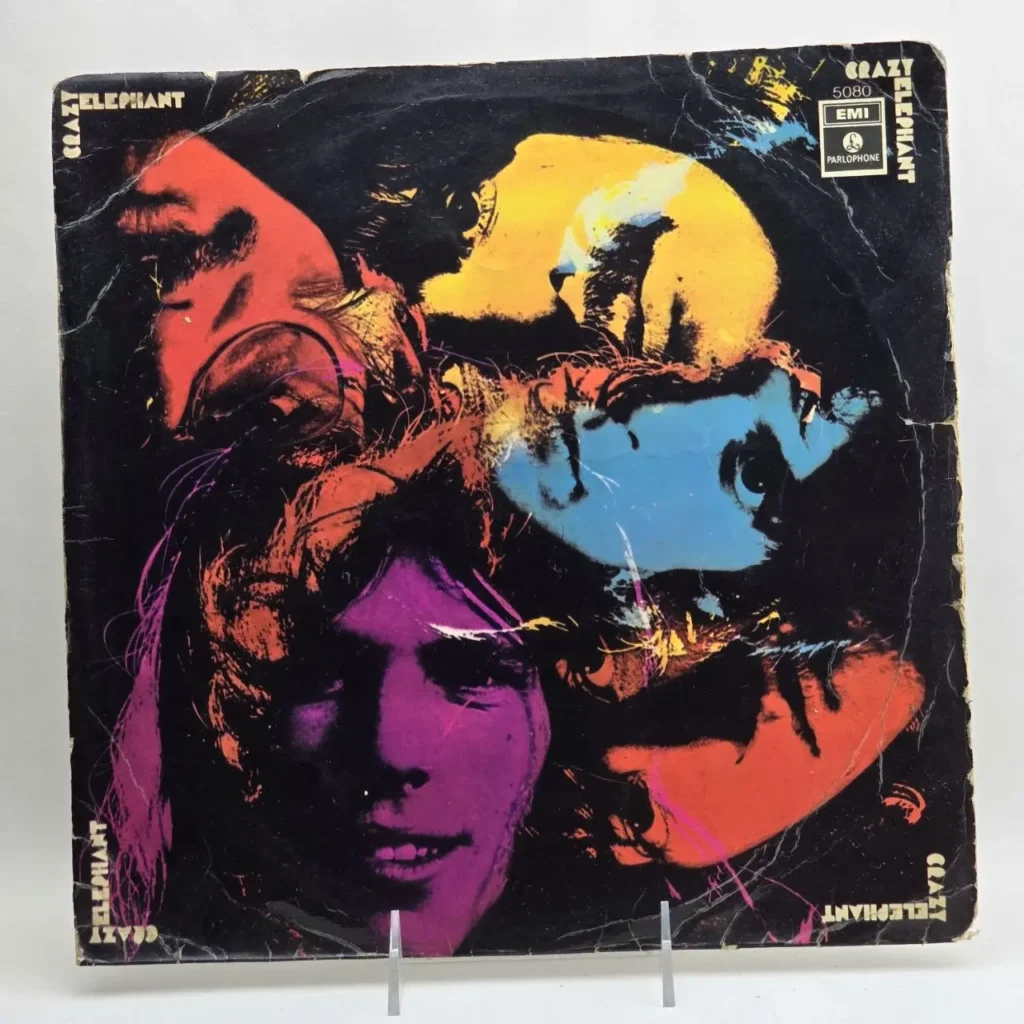 Portada de álbum de vinilo de Crazy Elephant, estilo pop art psicodélico con múltiples caras coloridas en fondo negro, sello Parlophone 5 by Remates Narvaja
