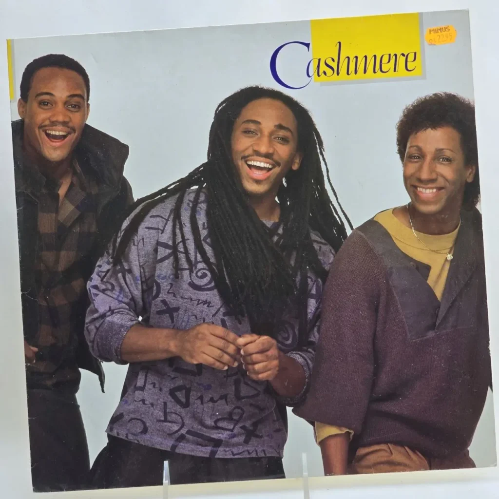 Portada del álbum Cashmere con tres hombres negros sonriendo, uno con rastas. by Remates Narvaja