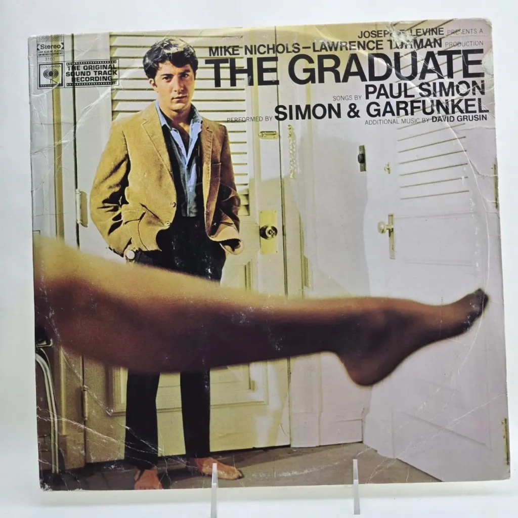 Carátula de vinilo The Graduate de Simon & Garfunkel, con Dustin Hoffman y la pierna de una mujer. by Remates Narvaja
