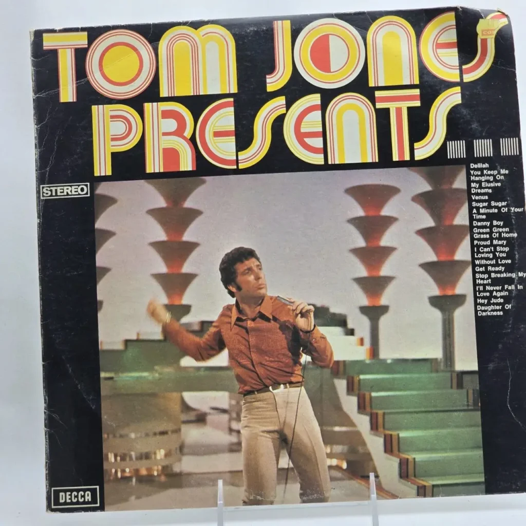 Portada del álbum de vinilo "Tom Jones Presents" de Tom Jones, mostrando al cantante en el escenario. by Remates Narvaja