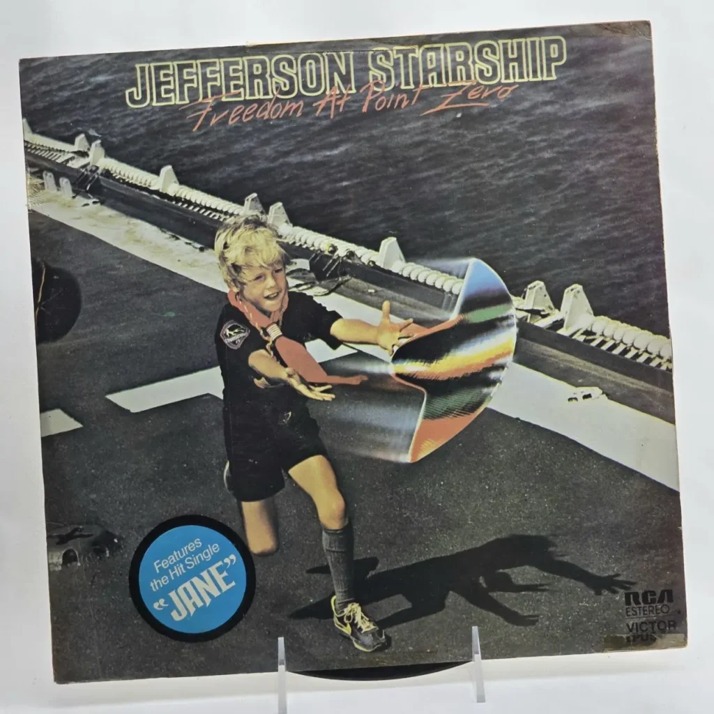 Portada del álbum Jefferson Starship Freedom At Point Zero, con un niño en un portaaviones interactuando con un objeto metálico brillante, y un by Remates Narvaja