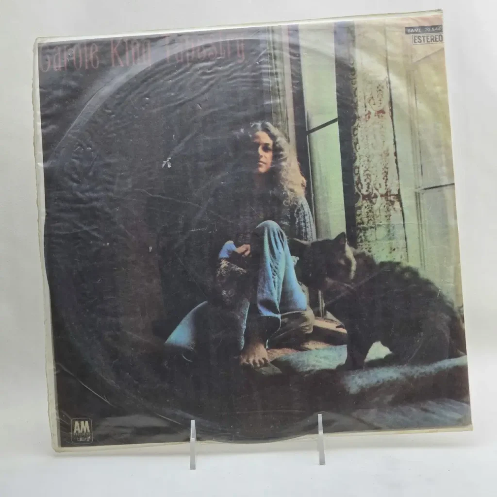 Portada del álbum de vinilo Carole King Tapestry, mostrando a la artista sentada junto a una ventana con un gato negro. by Remates Narvaja