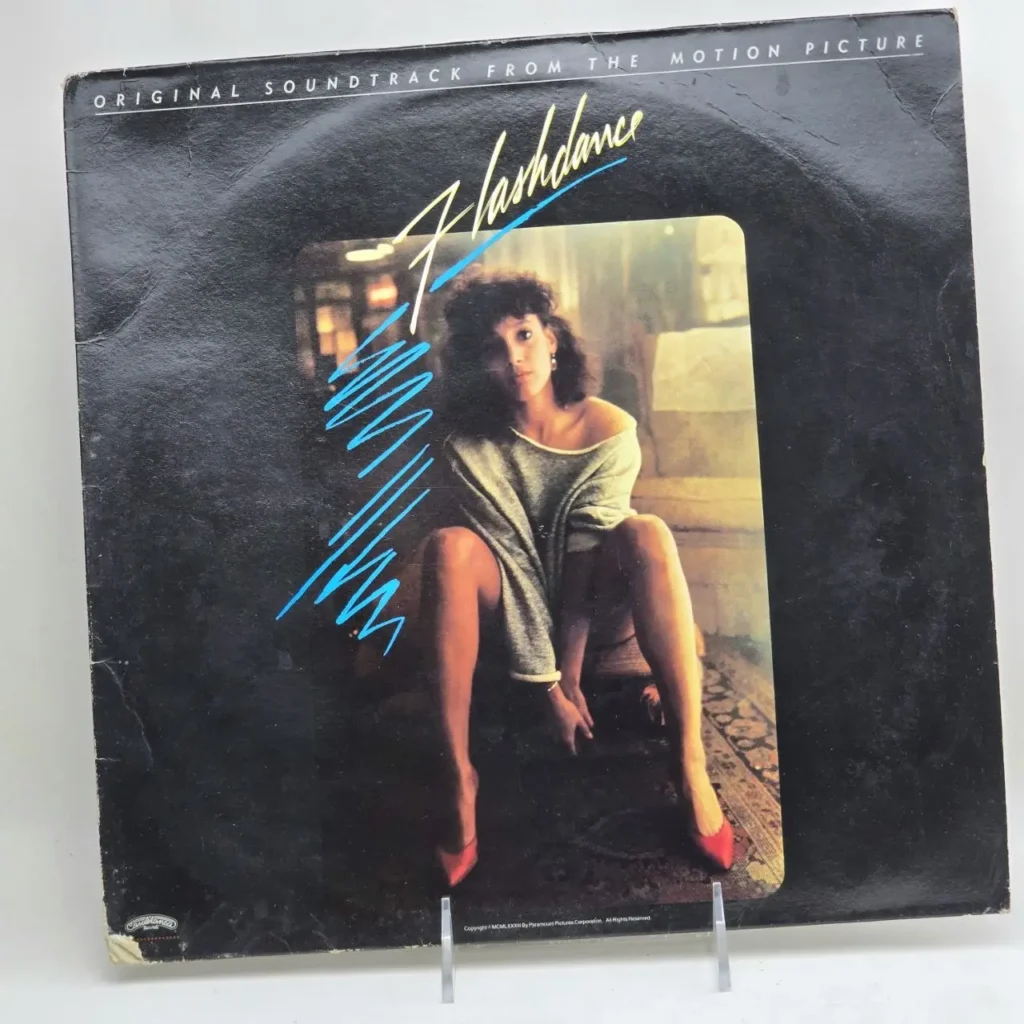 Portada de disco de vinilo Flashdance Original Soundtrack con mujer en sudadera gris y tacones rojos. by Remates Narvaja