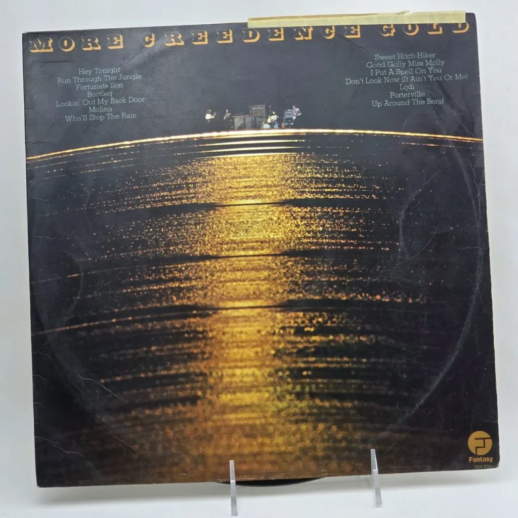 Portada del álbum de vinilo "More Creedence Gold" de Creedence Clearwater Revival, con diseño oscuro y dorado. by Remates Narvaja