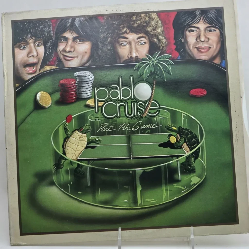 Portada del álbum Pablo Cruise - Part the Game, con miembros de la banda, fichas de póker y tortugas jugando ping-pong. by Remates Narvaja