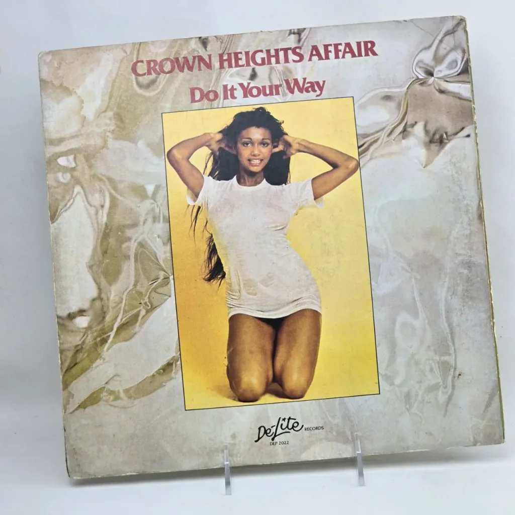 Portada del álbum Crown Heights Affair - Do It Your Way, con una mujer sonriente en camiseta blanca mojada, de De-Lite Records. by Remates Narvaja