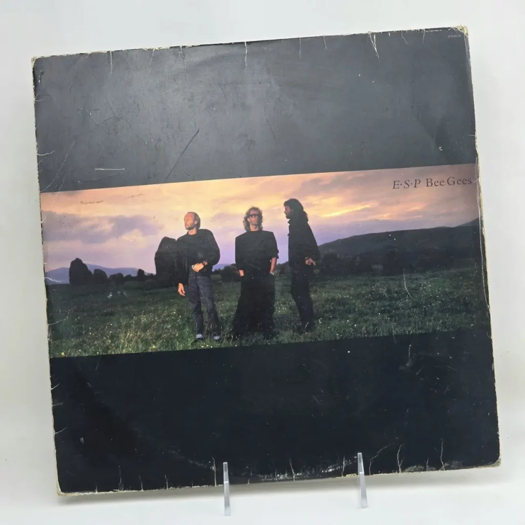 Portada del álbum de vinilo E.S.P. de Bee Gees, con los miembros de la banda en un campo. by Remates Narvaja
