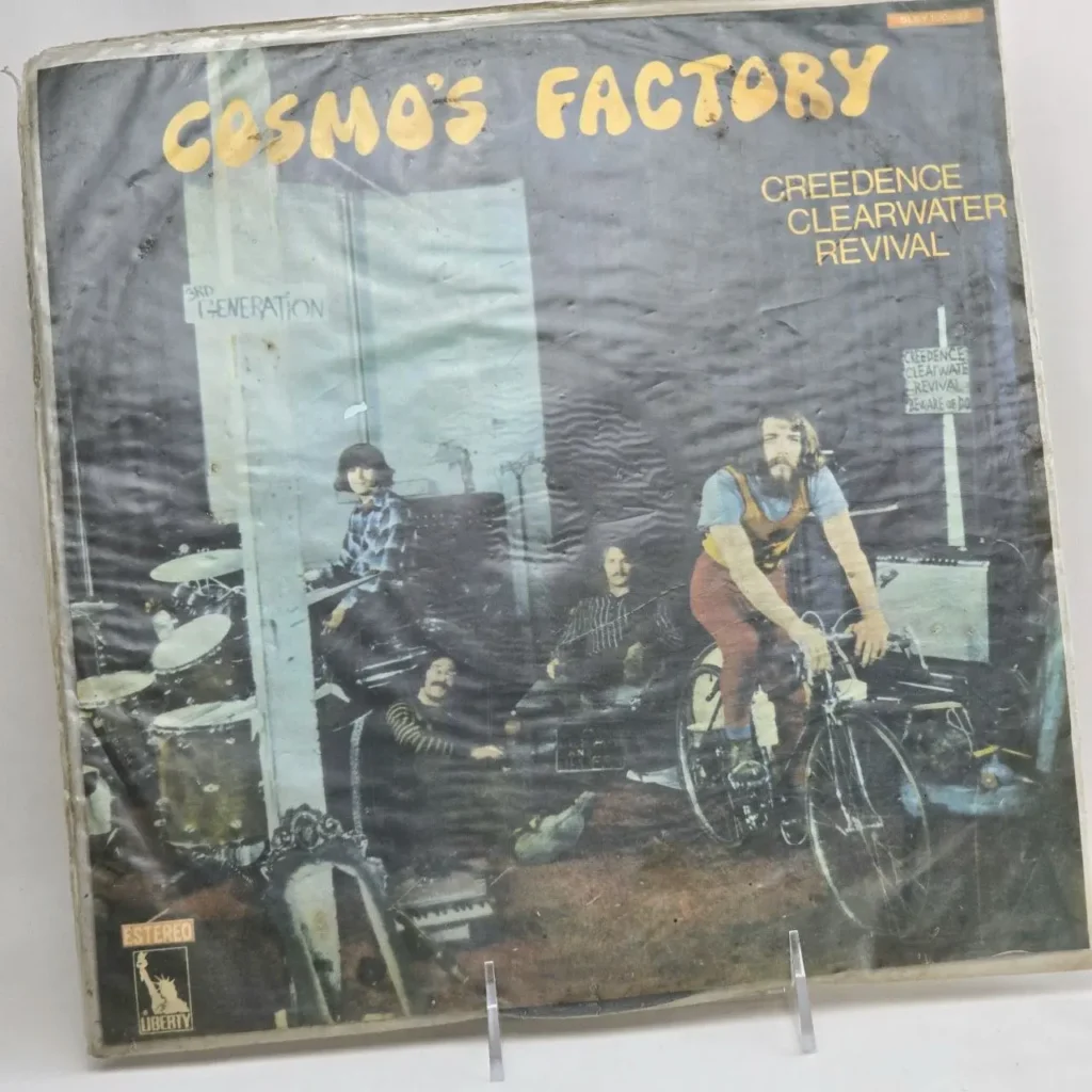 Portada del álbum Cosmo's Factory de Creedence Clearwater Revival con la banda y un miembro en bicicleta." by Remates Narvaja