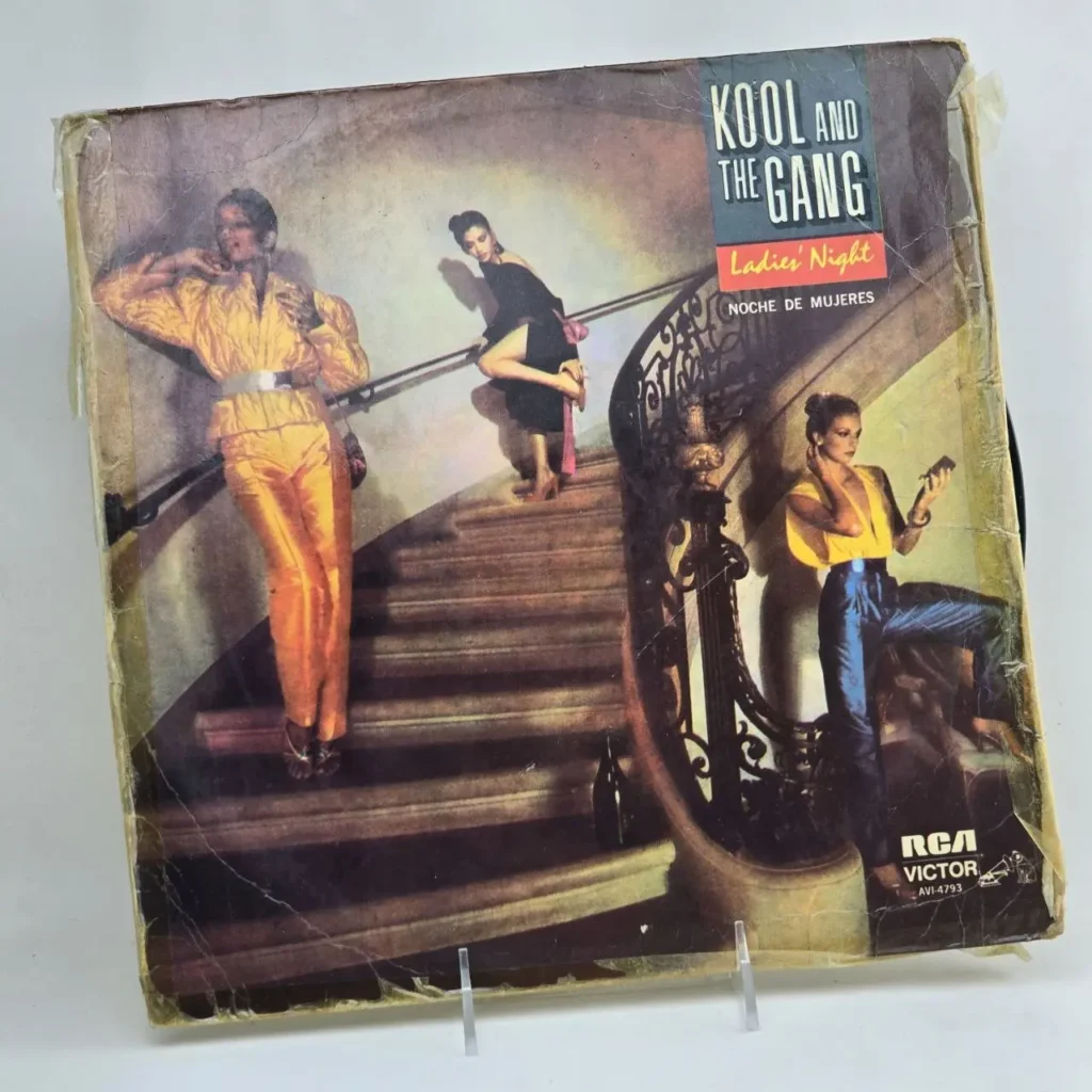 Portada del álbum "Ladies' Night" de Kool and the Gang, con tres mujeres en atuendos disco en una escalera. by Remates Narvaja