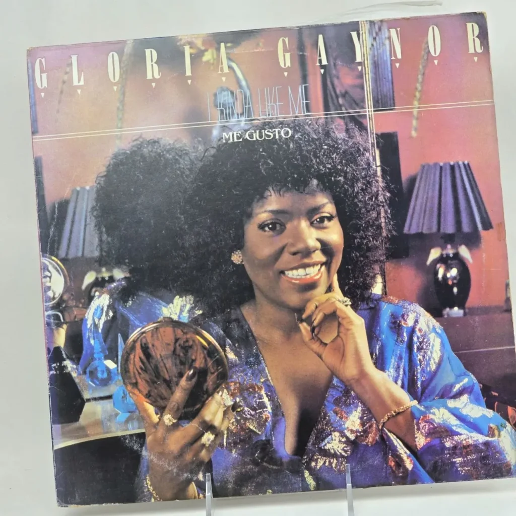 Portada del álbum de vinilo de Gloria Gaynor "I Kinda Like Me / Me Gusto", con la cantante sonriendo y sosteniendo un compacto. by Remates Narvaja