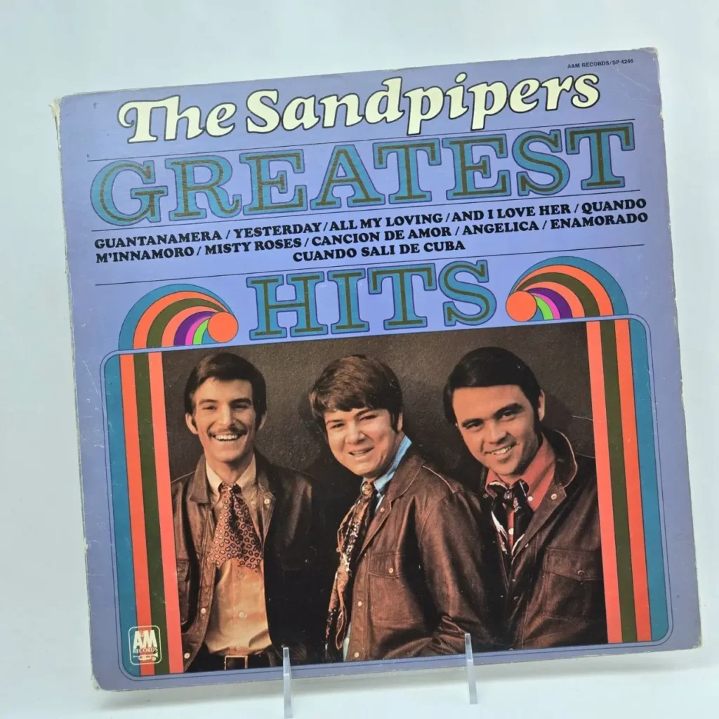 Portada de álbum de vinilo The Sandpipers Greatest Hits con los tres miembros sonriendo, fondo lavanda y lista de canciones como Guantanamera y by Remates Narvaja