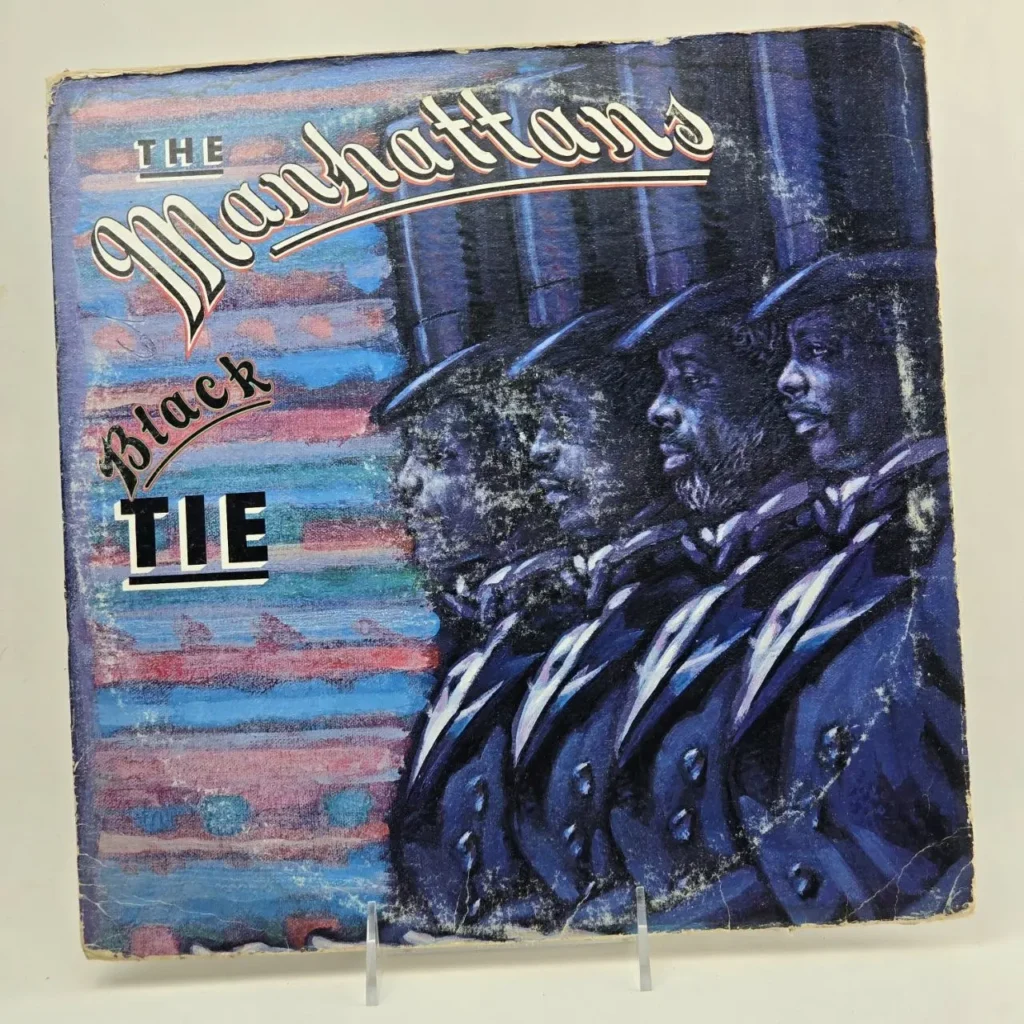 Portada del álbum The Manhattans Black Tie, con cuatro hombres en trajes oscuros y sombreros de copa. by Remates Narvaja