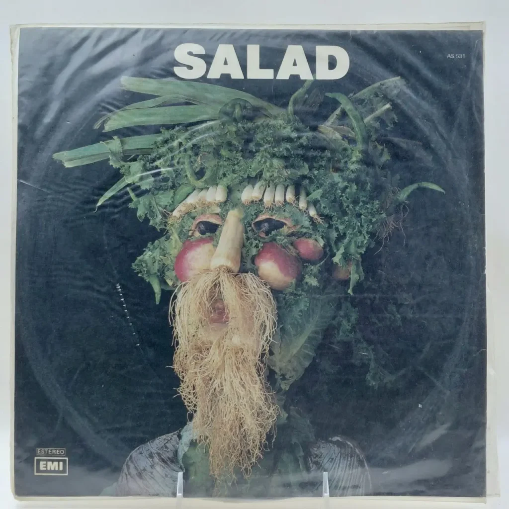 Portada del álbum "Salad" con una cara hecha de vegetales, hojas verdes y raíces. by Remates Narvaja