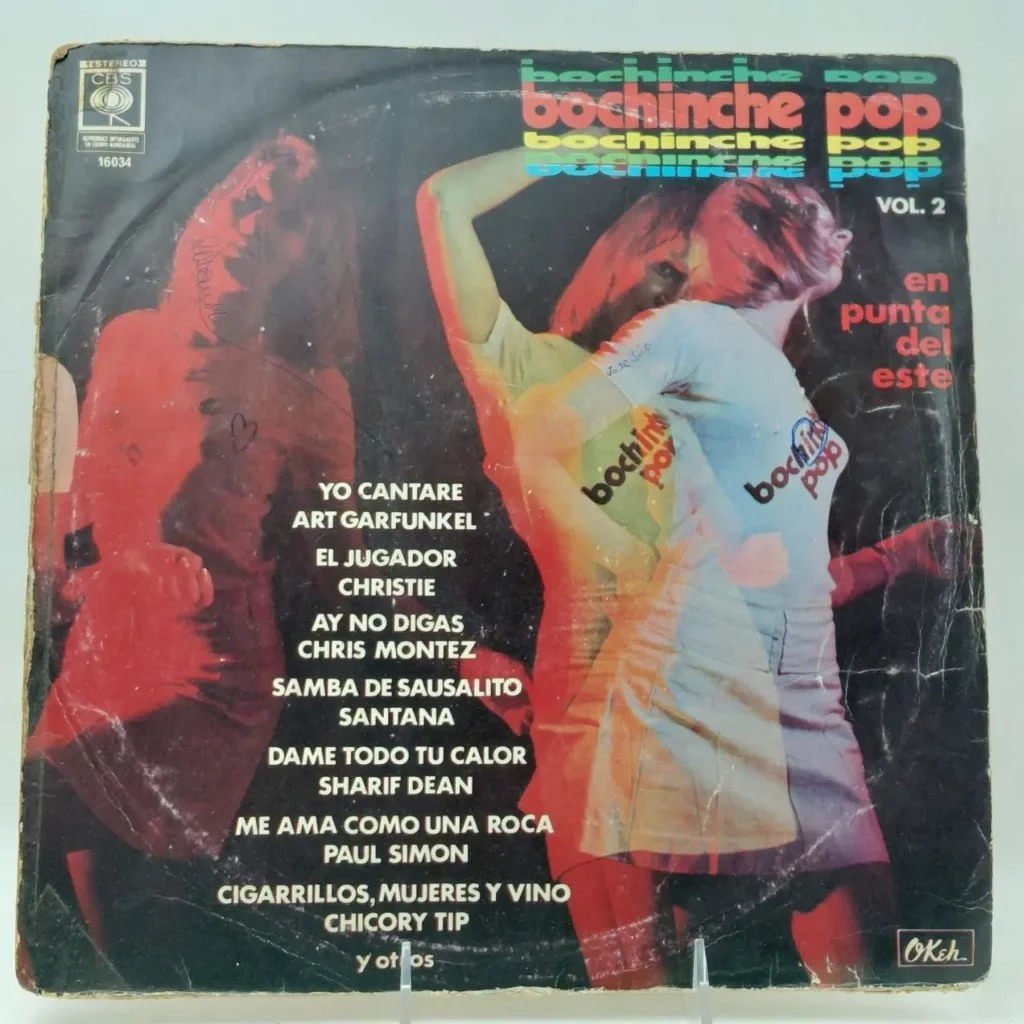 Portada de álbum "Bochinche Pop Vol. 2" con dos mujeres bailando y lista de canciones de artistas como Art Garfunkel, Santana by Remates Narvaja